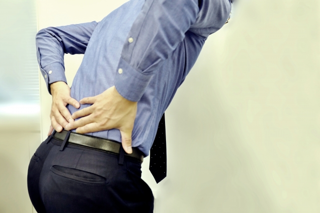 立ち上がるときに腰を押さえる男性