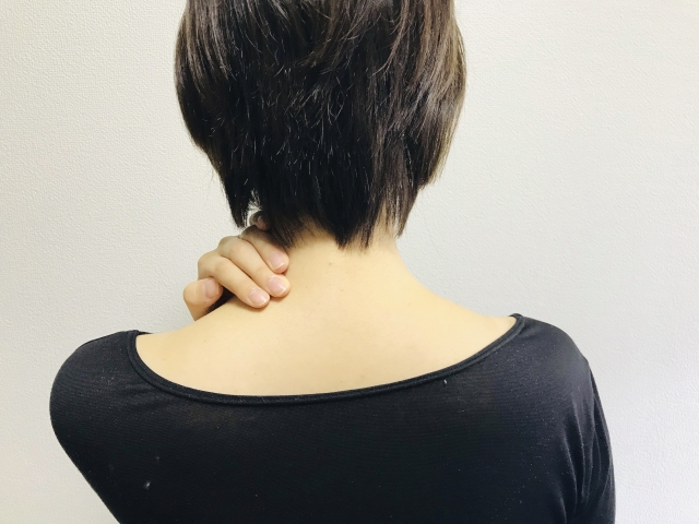 首すじの痛みを訴える様子